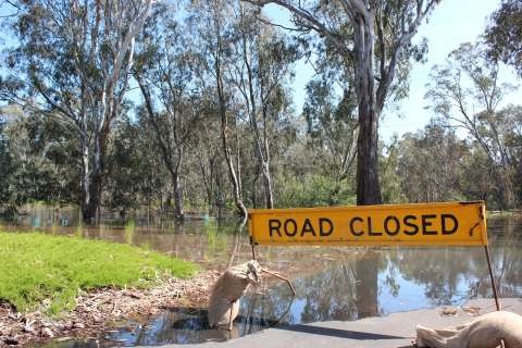 Road Closed sign across flooded road