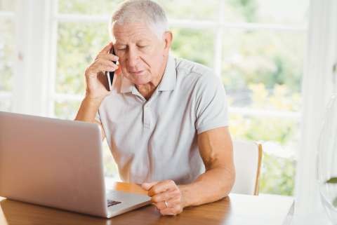 Mature man on laptop phone