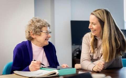 A younger and older person sitting at a table.